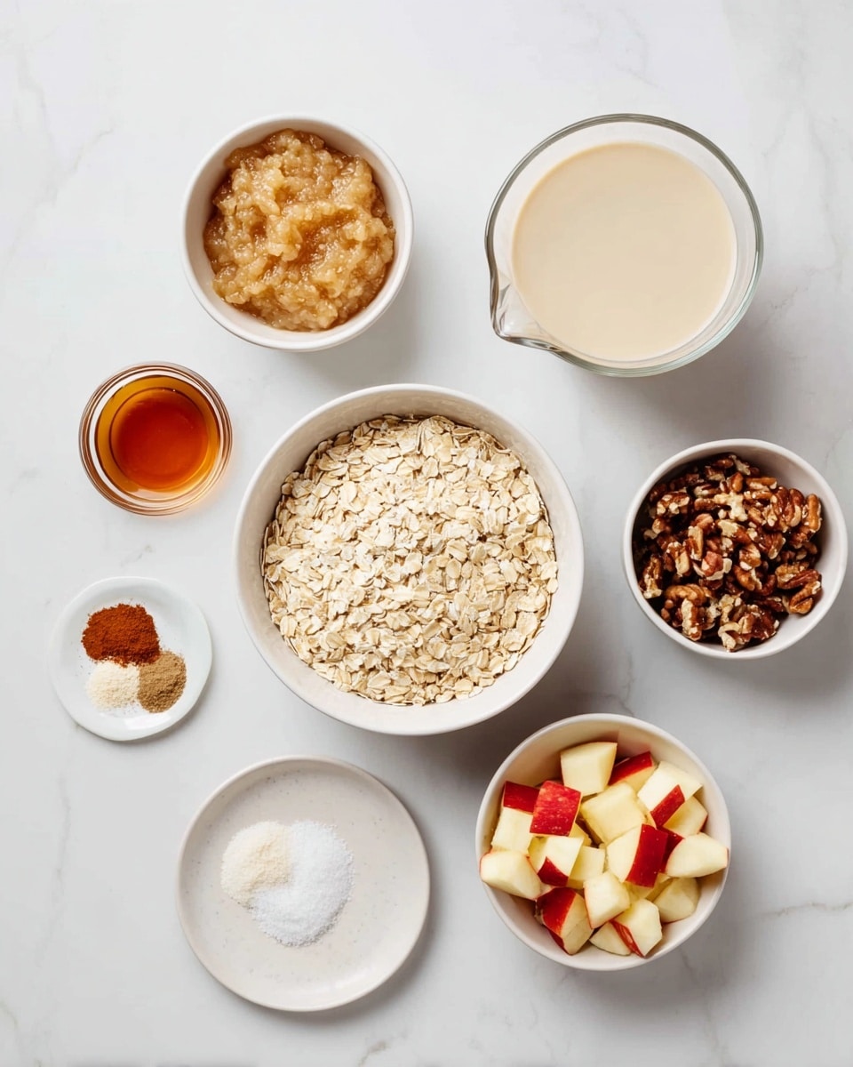 The image shows six small white bowls and a small clear glass jug arranged on a white marbled surface. At the center is a bowl filled with light beige rolled oats. Above it to the left is a bowl of light golden brown applesauce with a smooth texture. Above the oats to the right is a bowl of chopped dark brown nuts with rough texture. Next to those nuts on the far right is a clear glass jug filled with light beige liquid, likely a plant-based milk. Below the jug is a small round dish of clear amber honey. Below the oats is a bowl of finely chopped apple pieces with red skin and pale yellow flesh. To the left of the apple bowl is a small white plate holding three small piles of spices: cinnamon with a fine brown powder, white granulated salt, and white baking powder. The overall arrangement is neat and the colors are warm and natural. photo taken with an iphone --ar 4:5 --v 7