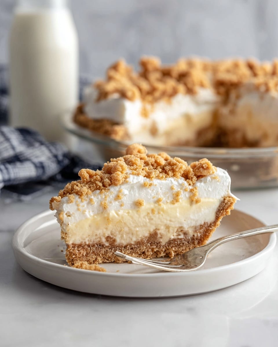 A slice of pie is shown on a white plate with three visible layers: a light beige crust at the bottom with a crumbly texture, a thick middle layer of creamy, pale yellow filling, and a fluffy white topping that looks like whipped cream. The top is sprinkled with uneven clusters of golden brown streusel. A fork is placed beside the slice on the plate, slightly touching the crust. In the background, the rest of the pie, with the same layers and topping, sits on a white marbled surface along with a blurred glass bottle of white milk. Photo taken with an iphone --ar 4:5 --v 7