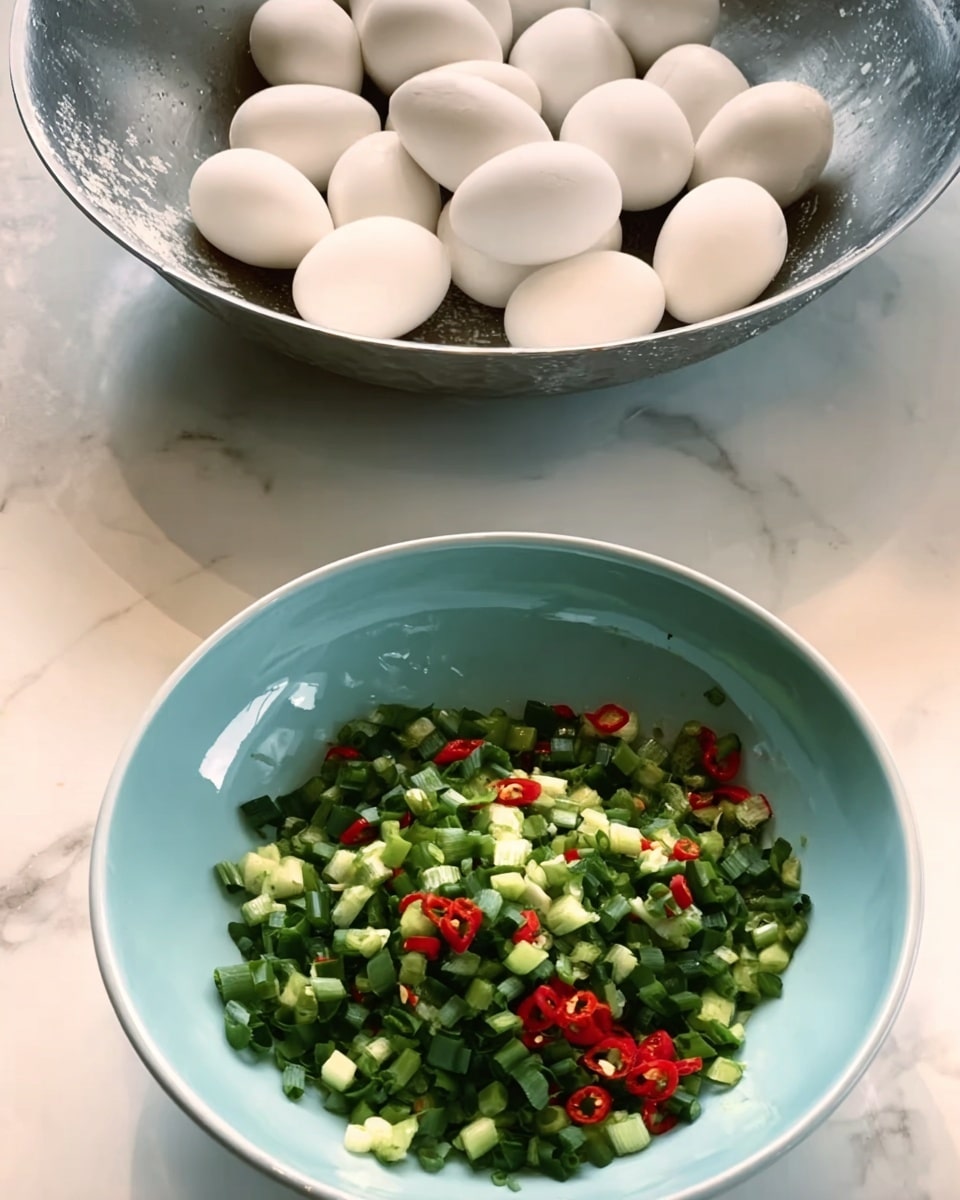 A light blue bowl filled with chopped green onions and small red chili pieces spread loosely across the bottom. Behind it, a larger shiny metal bowl holds a group of whole white eggs resting together. Both bowls sit on a white marbled surface. photo taken with an iphone --ar 4:5 --v 7