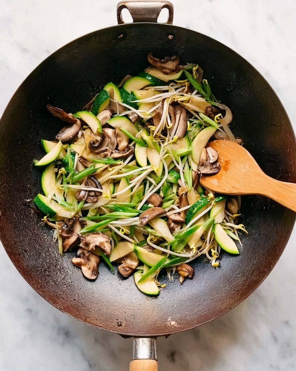 A dark wok filled with a mix of vegetables including light green and white zucchini slices, brown mushrooms, white bean sprouts, and bright green scallions. A wooden spoon with a light tan handle is resting inside the wok, stirring the vegetables. The wok is placed on a surface with a white marbled texture. The colors are natural and fresh, showing a simple and healthy stir-fry meal. photo taken with an iphone --ar 4:5 --v 7