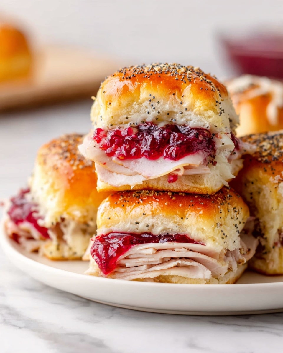 The image shows three sandwich pieces stacked on a white plate with a white marbled surface in the background. Each sandwich has a soft golden brown bun with poppy seeds on top. The bottom layer of each sandwich is filled with tender slices of light pink turkey, above that is a thin layer of melted white cheese, and the top layer consists of a thick spread of bright red cranberry sauce. The sandwich on top is slightly lifted, showing the inside layers clearly. The photo taken with an iphone --ar 4:5 --v 7