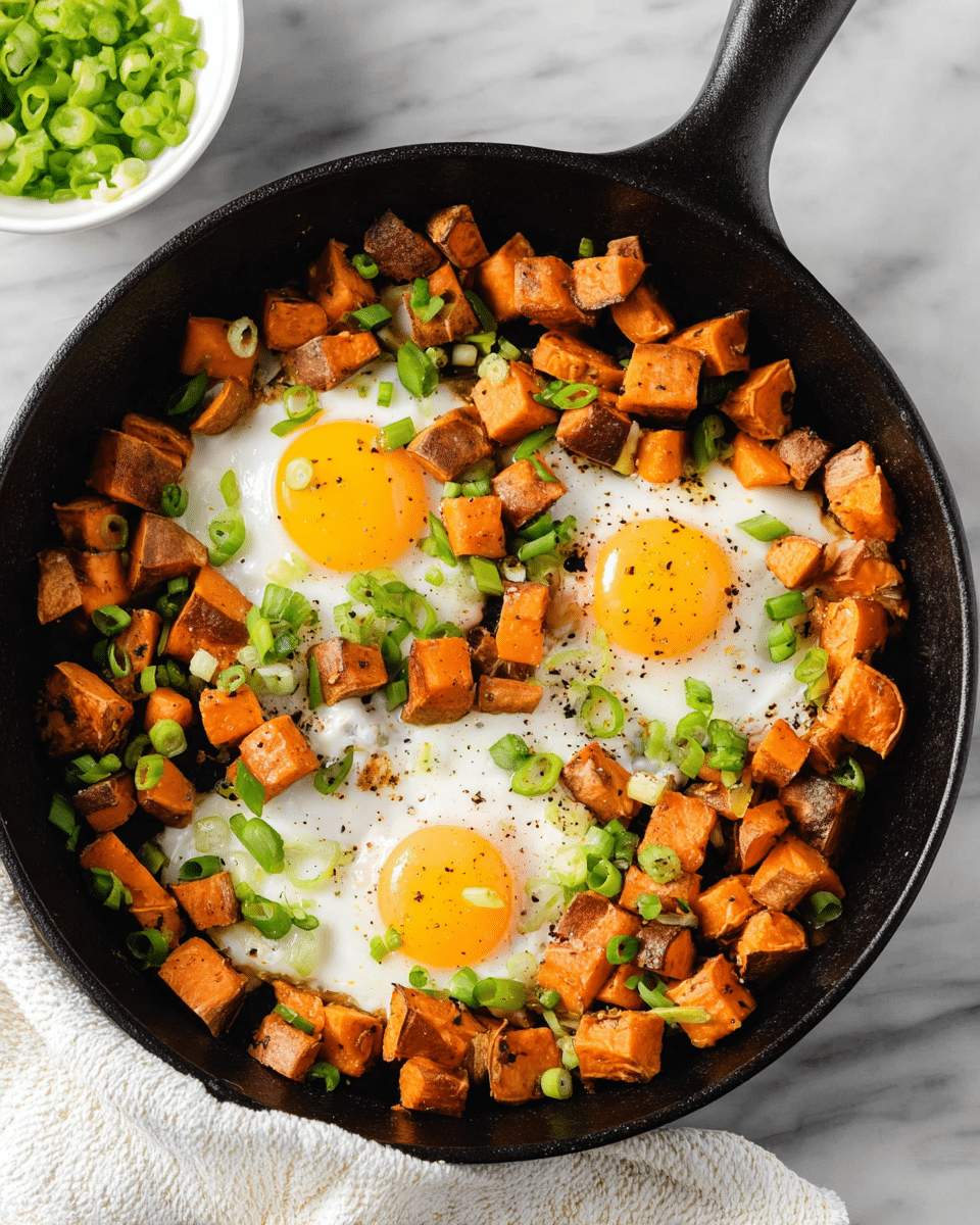 A black cast iron pan filled with two white eggs cooked sunny-side up, with a soft and slightly runny yellow center, surrounded by many small golden-brown cubes of roasted sweet potatoes with crispy edges and skins still on. Green sliced scallions are spread over the top, adding a fresh pop of color. Some black sesame seeds and small herbs are sprinkled lightly over the eggs and potatoes. A silver fork is scooping a portion of sweet potato and egg, showing the texture up close. The pan sits on a white marbled surface with a cloth napkin underneath. photo taken with an iphone --ar 4:5 --v 7