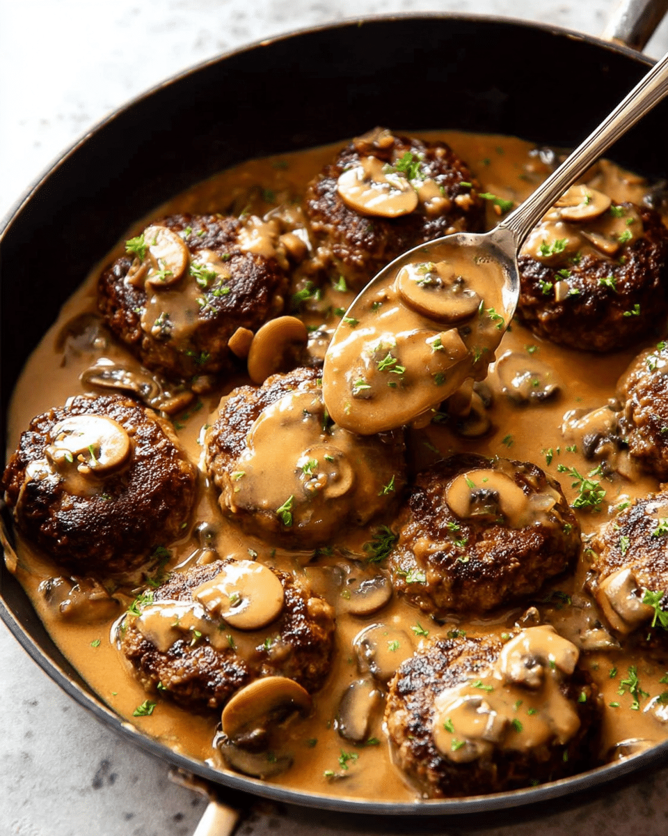 A black skillet filled with nine browned meat patties, each covered in a thick light brown mushroom sauce with sliced mushrooms scattered across the patties and sauce. The sauce looks smooth and creamy, pooling around and slightly overlapping the patties. Small bits of green herbs are sprinkled on top of the patties and sauce for garnish. A silver spoon lifts one patty, draped in sauce and mushrooms, from the skillet. The skillet sits on a white marbled textured surface. photo taken with an iphone --ar 4:5 --v 7