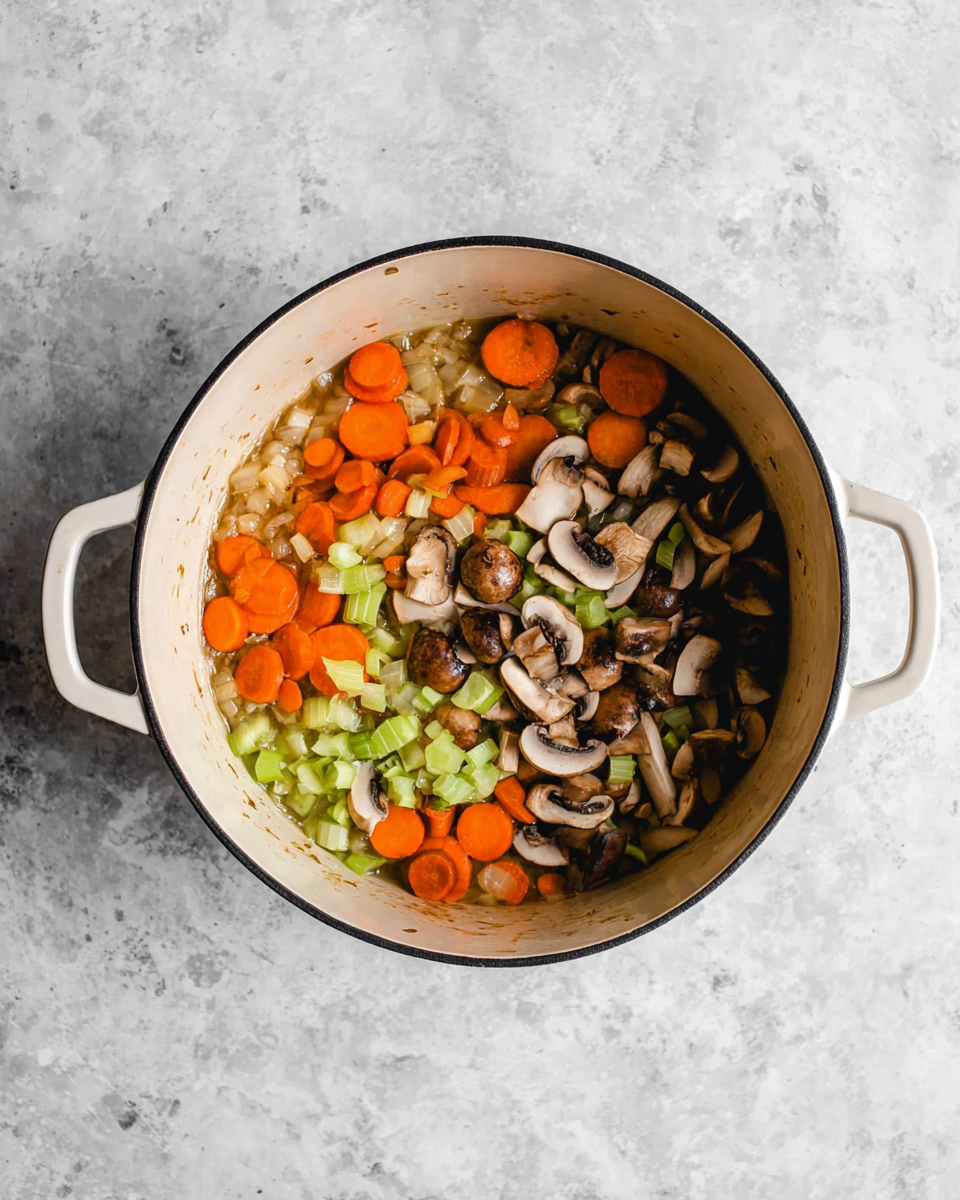 Creamy Leftover Turkey Wild Rice Soup Recipe 4 Inside a round white pot with two side handles, there is a mix of vegetables sitting at the bottom. The first layer is small pieces of light brown onion spread evenly. On top of that, orange sliced carrots and light green celery pieces are scattered around. The last layer has dark brown sliced mushrooms placed randomly over the other vegetables. The pot sits on a white marbled surface. photo taken with an iphone --ar 4:5 --v 7