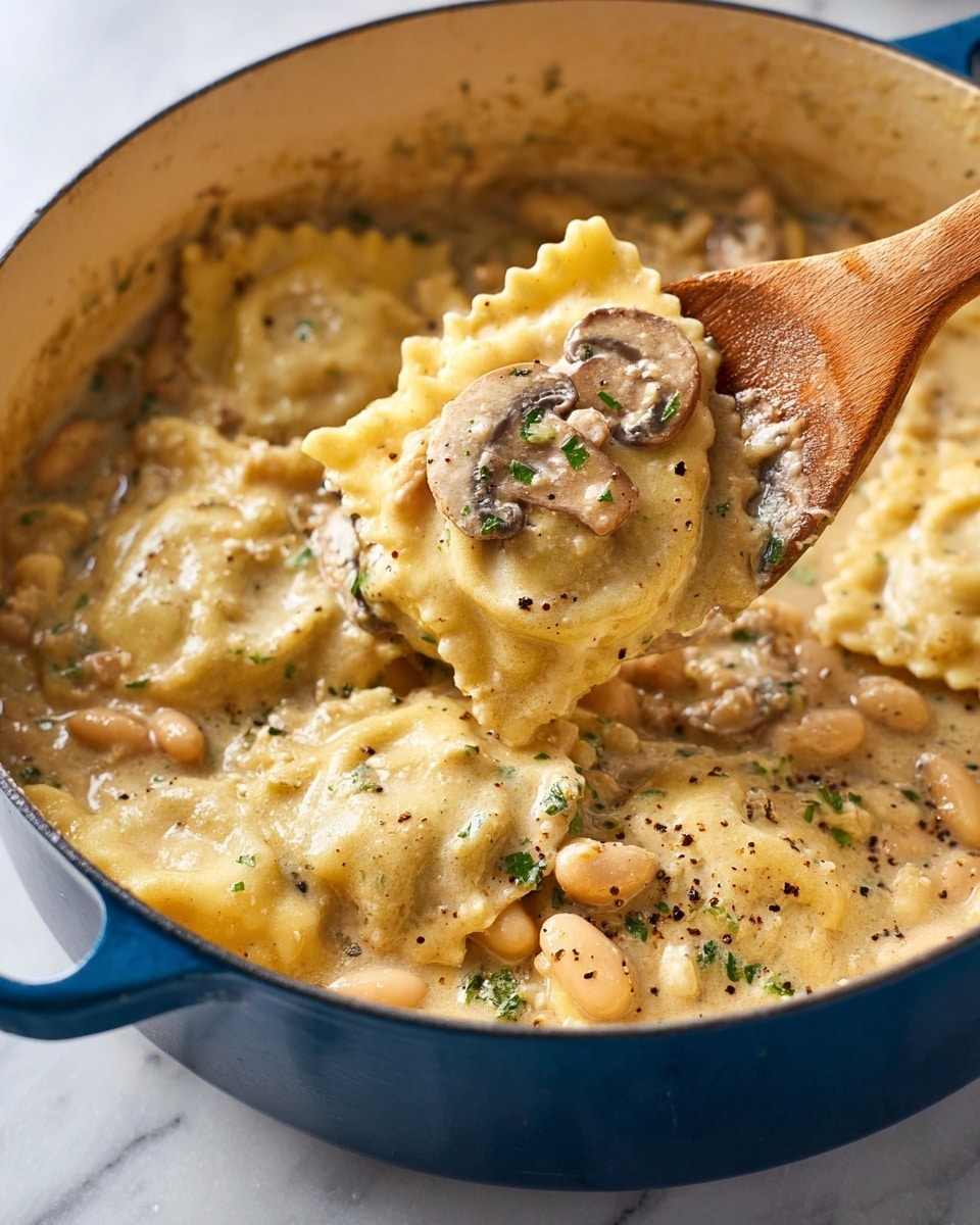 A blue pot filled with creamy ravioli pasta is shown close-up on a white marbled surface. The ravioli have a pale yellow color with ruffled edges and are submerged in a thick, creamy sauce with visible pieces of sliced brown mushrooms and small white beans. A wooden spoon lifts a ravioli piece covered in sauce and topped with a mushroom slice and green herb bits, sprinkled with black pepper. The scene looks warm and comforting, with the pasta and sauce fully covering the pot’s inside. Photo taken with an iphone --ar 4:5 --v 7