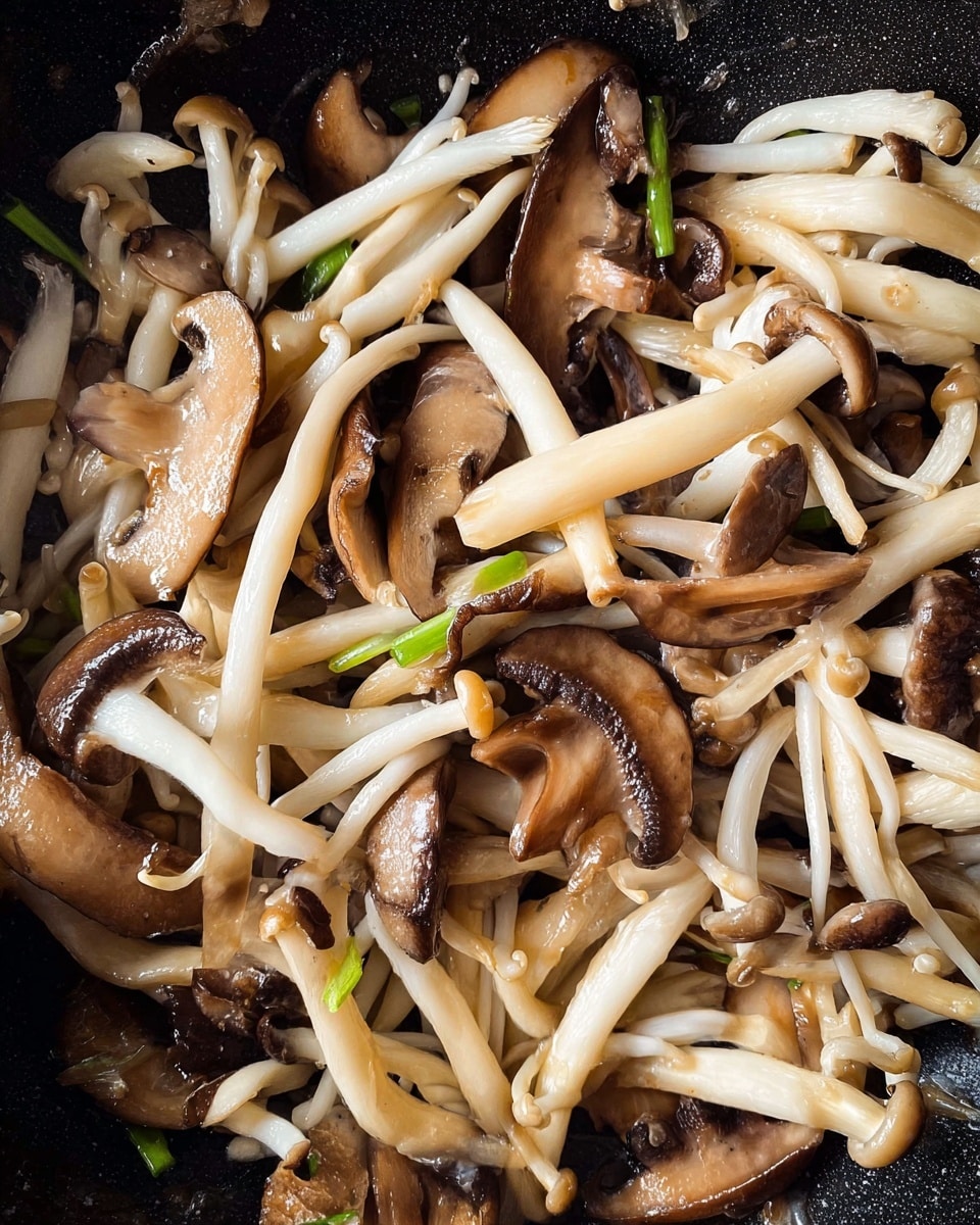 A close-up view of a mix of cooked mushrooms in a black pan showing two types: long, thin, white enoki mushrooms with small caps and flatter, brown shiitake mushroom slices with darker edges and visible gills. The mushrooms are lightly browned and slightly glossy from cooking, mixed with bits of green onion scattered among them. The texture looks soft and tender with some shininess from cooking oil. Photo taken with an iphone --ar 4:5 --v 7