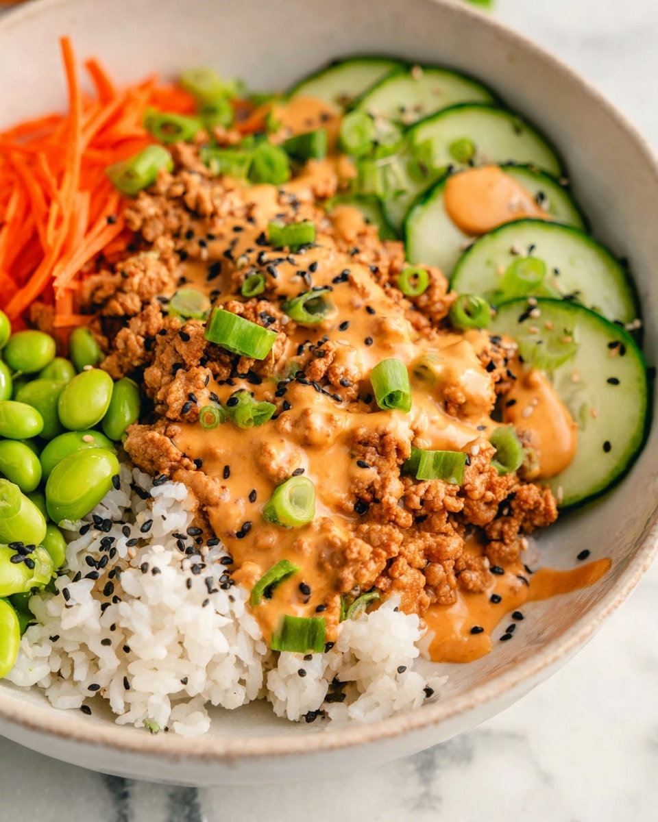 The dish is served in a white bowl with a white marbled texture underneath, showing four main layers arranged side by side. On the bottom left, there is a layer of white rice sprinkled with black sesame seeds. Next to it, bright green edamame beans form a small mound. Above the rice and edamame, there are thin orange carrot strips. On the right side of the bowl, there is a large portion of light brown cooked ground meat covered with an orange creamy sauce. Green chopped scallions and black sesame seeds are sprinkled over the meat and sauce. On the top right, there are circular slices of dark green cucumber, also lightly topped with the same orange sauce. The image is close-up, showing detail in texture and color contrast. Photo taken with an iphone --ar 4:5 --v 7