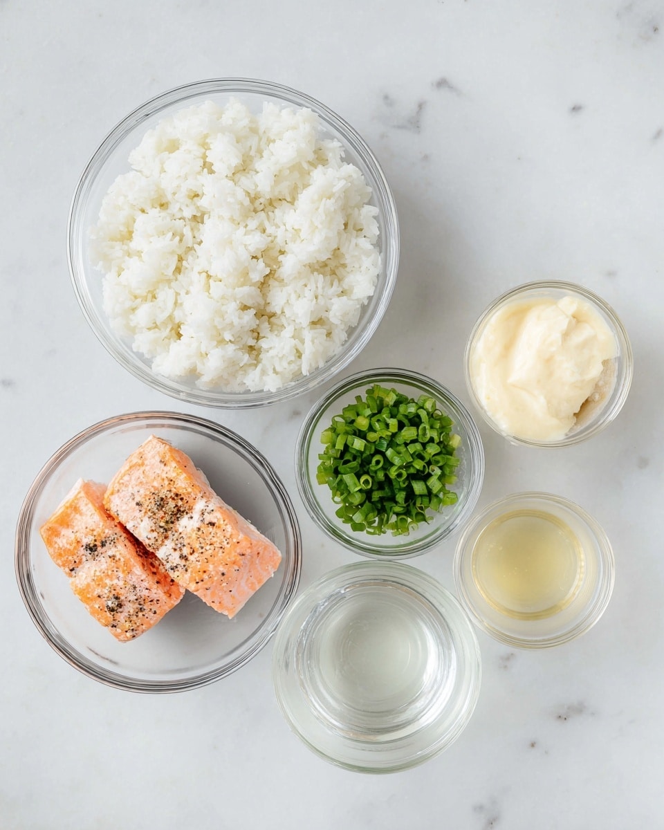 A top-down view shows six clear glass bowls arranged on a white marbled surface. The largest bowl at the top center holds fluffy white cooked rice with a soft texture. To the lower left is a medium bowl with two pieces of cooked salmon, pink-orange in color, sprinkled with black pepper. On the right side, three small bowls are placed vertically: the top one has a creamy pale yellow sauce, the middle one contains vibrant green chopped scallions, and the bottom one holds a small amount of pale yellow liquid. There is also a smaller clear bowl below the scallions and sauce bowls, containing a clear liquid. All bowls show the food clearly through their transparent surfaces. photo taken with an iphone --ar 4:5 --v 7