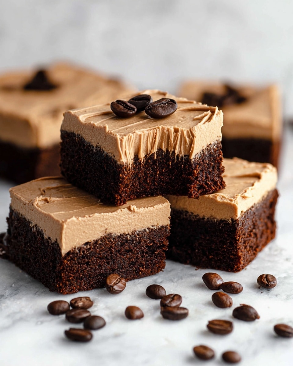 The image shows four brownie squares with two layers on a white marbled surface. The bottom layer is dark brown and looks dense and moist, while the top layer is light brown, smooth, and creamy frosting with visible textured strokes. One brownie square is stacked partly on another, and it has a bite taken out, showing the thick frosting and dense brownie inside. On top of two brownies are two dark brown coffee beans as decoration. Around the squares are scattered coffee beans with a glossy shine. The photo taken with an iphone --ar 4:5 --v 7
