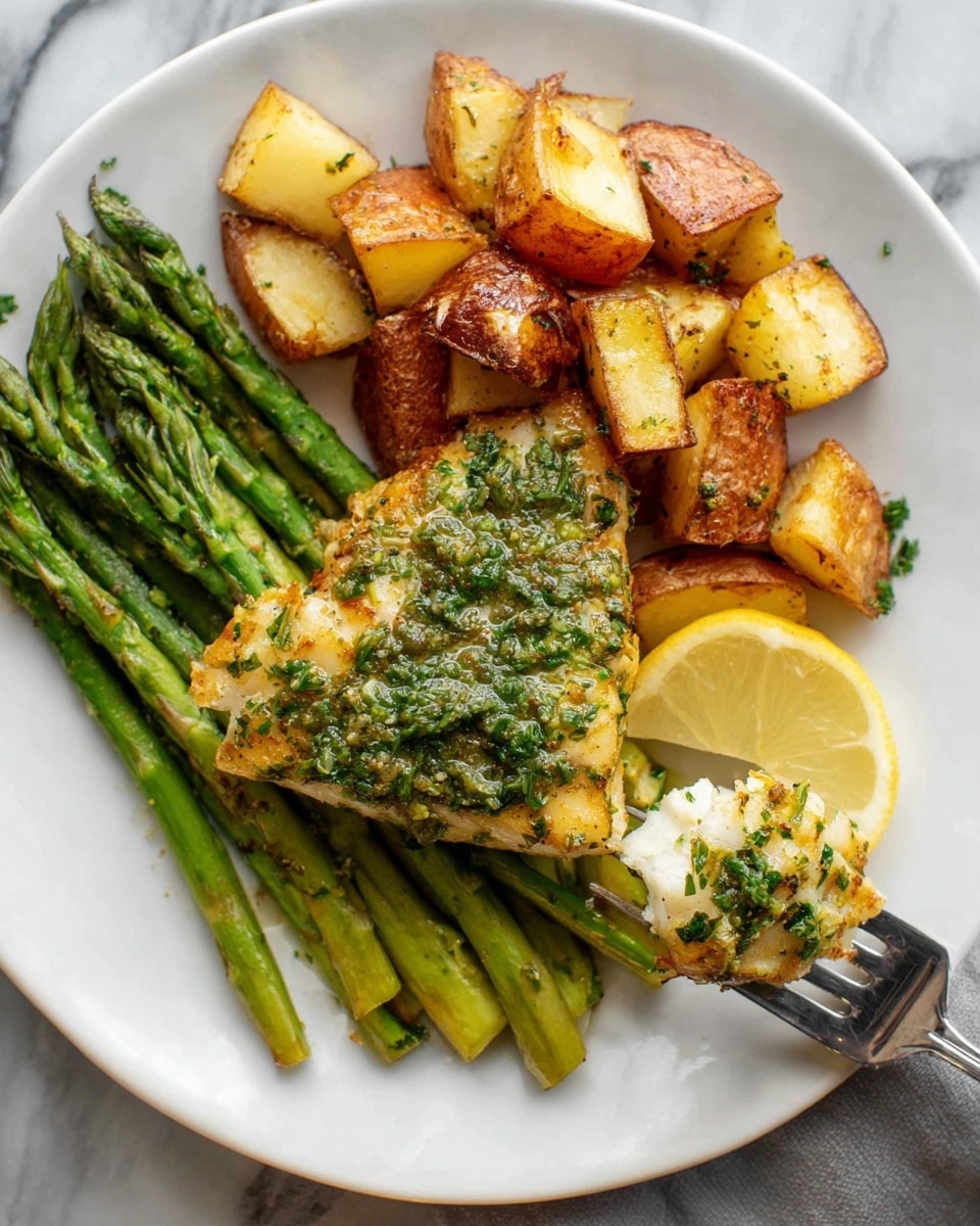 A white plate holds a meal with three main layers: bright green asparagus spears at the bottom arranged in a neat bundle, a large golden-brown piece of fish coated with a green herb sauce sitting on top of the asparagus, and a portion of crispy roasted potato cubes with browned edges placed above the fish. A lemon wedge is tucked under the fish near the bottom of the plate. On the right side, a silver fork holds a bite-sized piece of the fish with visible herbs. The plate is set on a white marbled surface. photo taken with an iphone --ar 4:5 --v 7