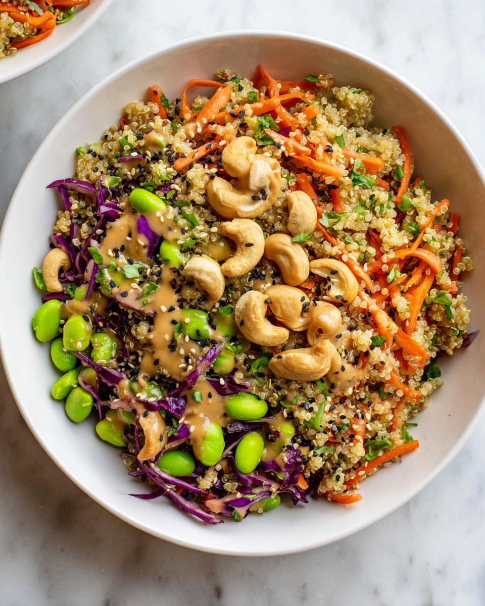 A white bowl filled with a colorful quinoa salad showing multiple layers: the bottom layer is light quinoa grains mixed with shredded bright orange carrots, thin strips of purple cabbage, and small chopped green herbs. On top of this, there are bright green edamame beans scattered evenly. A creamy tan sauce with a smooth texture is drizzled over the salad, and black and white sesame seeds are sprinkled on top. Around the edge of the bowl, there is a layer of whole roasted cashews with a light golden-brown color and a slightly rough texture. The bowl is placed on a white marbled surface. photo taken with an iphone --ar 4:5 --v 7