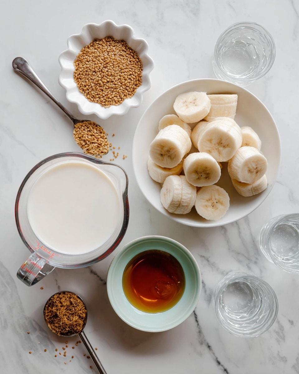 The image shows a white marbled surface with several small containers arranged neatly. In the center right, there is a bowl filled with thick banana slices that are pale yellow and white. To the left of the bowl, a small white scalloped dish holds golden flax seeds, with some seeds scattered nearby. Above the banana bowl, a small glass bowl contains a light brown, smooth mixture with tiny air bubbles. Below the flax seeds, a small white bowl with a pale turquoise interior has a dark amber liquid that looks like syrup. At the bottom left, there is a clear glass measuring cup filled with white milk. Two empty clear glasses are placed on the right side. A shiny metal measuring spoon labeled 1/8 tsp lies near the bowls. photo taken with an iphone --ar 4:5 --v 7