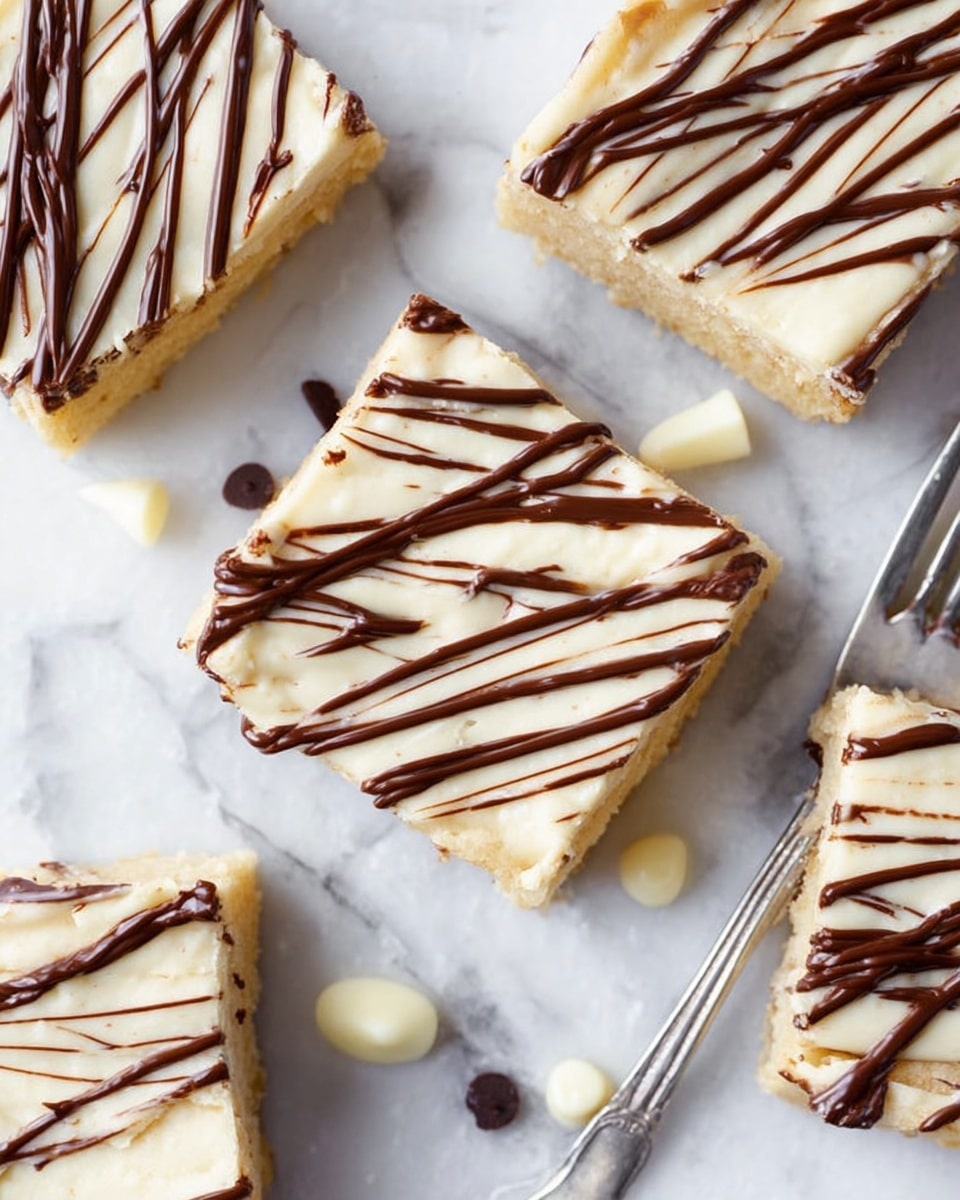 The image shows a close-up of five square pieces of a light-colored dessert, possibly blondies, arranged on a white marbled surface. Each piece has two layers: a soft and slightly crumbly pale yellow base and a thin, smooth icing layer on top. Dark brown and white chocolate sauces are drizzled in parallel diagonal lines over the icing, creating a striped pattern. Small drops of white and dark chocolate are scattered around the dessert pieces. A shiny silver fork is partially visible near the lower right corner, resting on the white marbled surface. Photo taken with an iphone --ar 4:5 --v 7