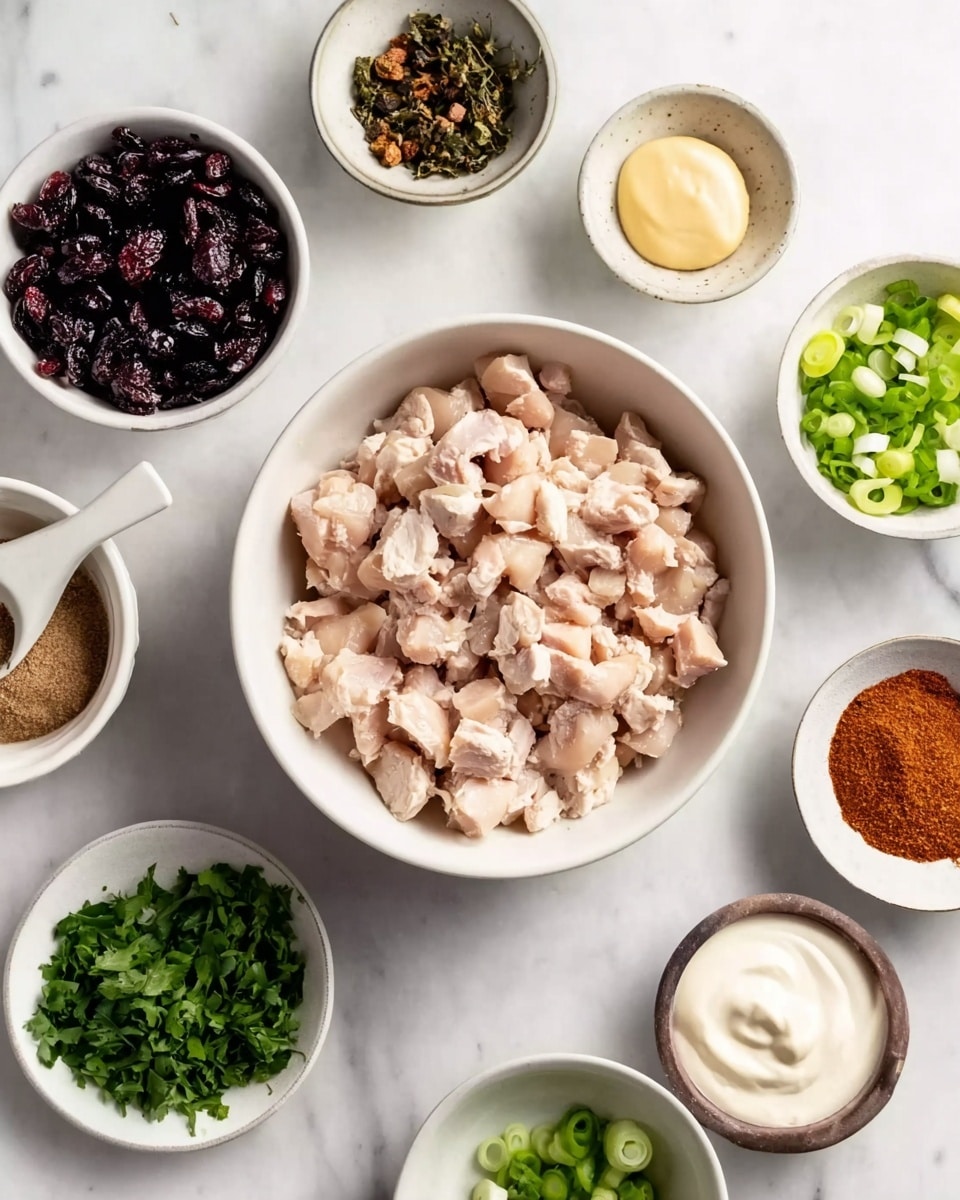 The image shows a white bowl in the center filled with small pieces of cooked light pinkish chicken. Surrounding the main bowl are smaller white bowls and dishes arranged neatly on a white marbled surface. One bowl contains dark dried cranberries, another has chopped green onions with white parts visible, and a third holds a mix of brown and reddish spices in powder form. There is also a dish with chopped fresh green herbs and a small bowl of light yellow mustard. A dollop of smooth white mayonnaise is placed directly on the marble surface. The colors range from light pinks and whites to dark purples, greens, and warm spices, creating a fresh and natural look. photo taken with an iphone --ar 4:5 --v 7
