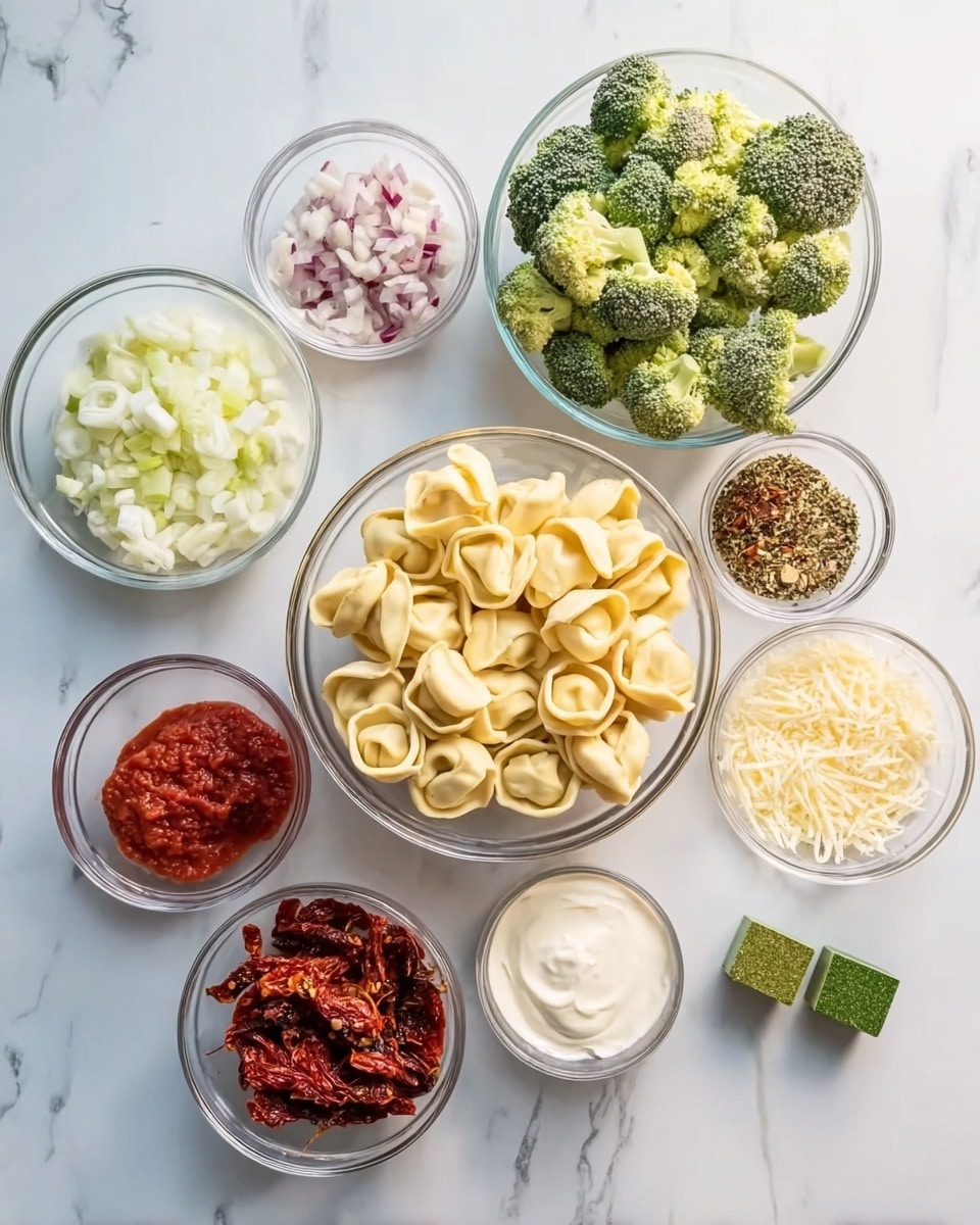 The image shows nine clear glass bowls arranged on a white marbled surface, each containing different food ingredients. In the center is a bowl filled with uncooked tortellini pasta, pale yellow and firm. Around it, clockwise from top left, there are broccoli florets with a fresh green color and rough texture, finely chopped shallots in soft pink and white, minced garlic in small pale yellow pieces, bright red tomato paste, a small bowl of cream with a smooth white texture, sun-dried tomatoes in deep reddish-brown strips, a green cube of seasoning, and a mix of dry herbs and spices in dark green, red, and brown hues in one bowl, and grated cheese in fine white shreds. Everything is evenly spaced and neatly placed, showcasing the ingredients clearly. Photo taken with an iphone --ar 4:5 --v 7