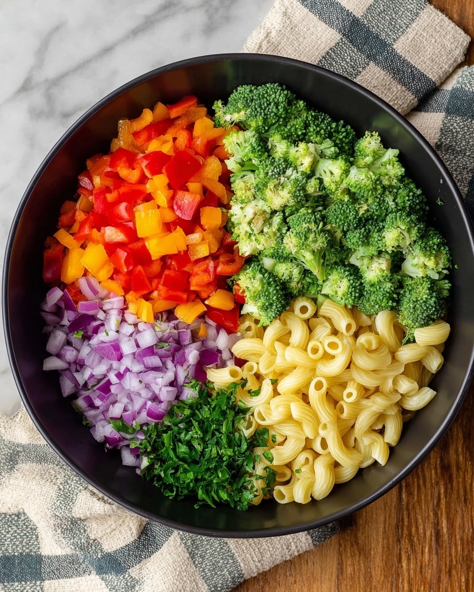 A black bowl filled with five layers of ingredients placed side by side, starting from the top left with bright red and orange chopped bell peppers, moving to vibrant green broccoli florets on the top right, below them a section of finely chopped purple onions, to the left of that a small pile of chopped green herbs, and finally at the bottom left, a layer of pale yellow elbow pasta. The bowl is on a white marbled surface, with a beige and blue checkered cloth partially underneath. photo taken with an iphone --ar 4:5 --v 7