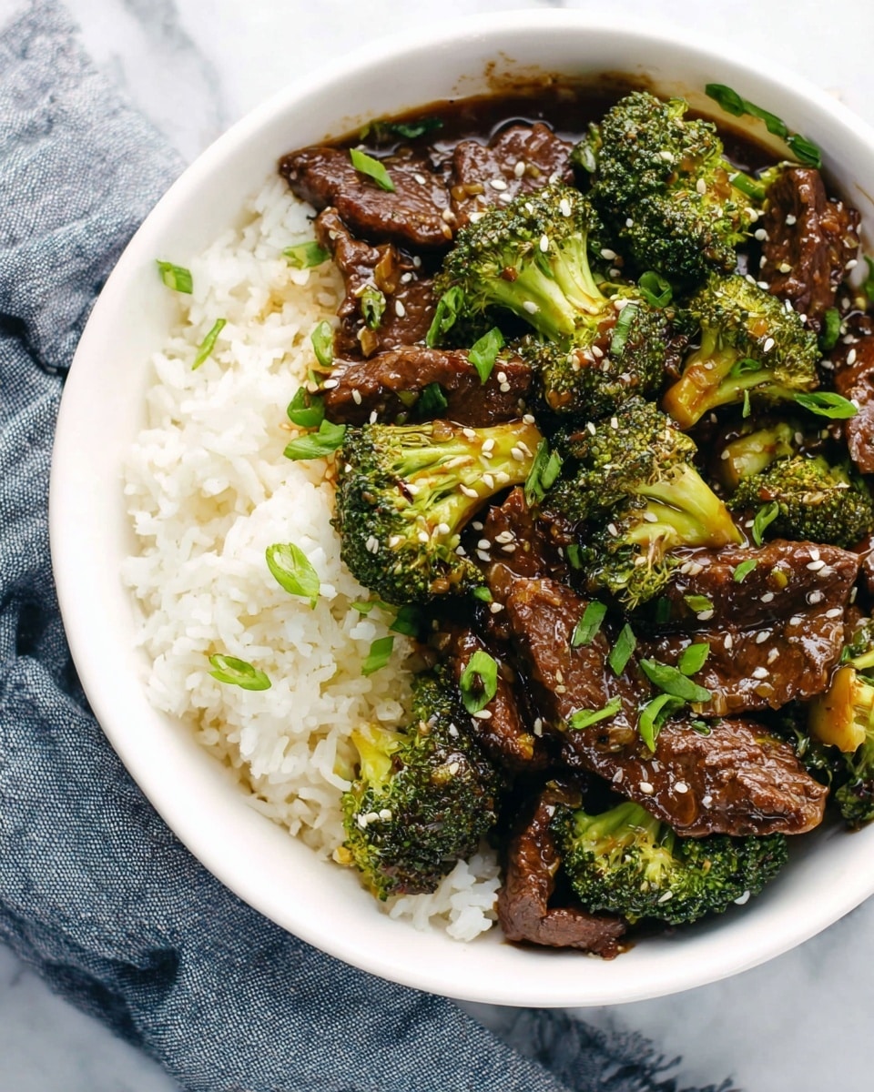A white bowl filled with two main layers: on the right side, a bed of white rice with a light, fluffy texture; on the left and center parts, dark brown, glossy beef pieces mixed with bright green broccoli florets. The beef and broccoli are coated in a shiny sauce, sprinkled with small white sesame seeds and chopped green onions. The bowl sits on a white marbled surface with a folded blue and white cloth next to it. photo taken with an iphone --ar 4:5 --v 7