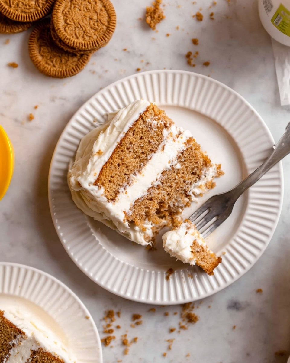 A slice of two-layer light brown cake with white cream frosting between and around the layers is on a white plate with ridged edges. A fork on the plate holds a small bite of cake with cream. In the top left corner, two round brown sandwich cookies with white filling and a broken cookie piece nearby are visible. Crumbs are scattered on a white marbled surface under and around the plate. Another partially visible plate with a similar slice of cake is in the bottom left corner. Photo taken with an iphone --ar 4:5 --v 7