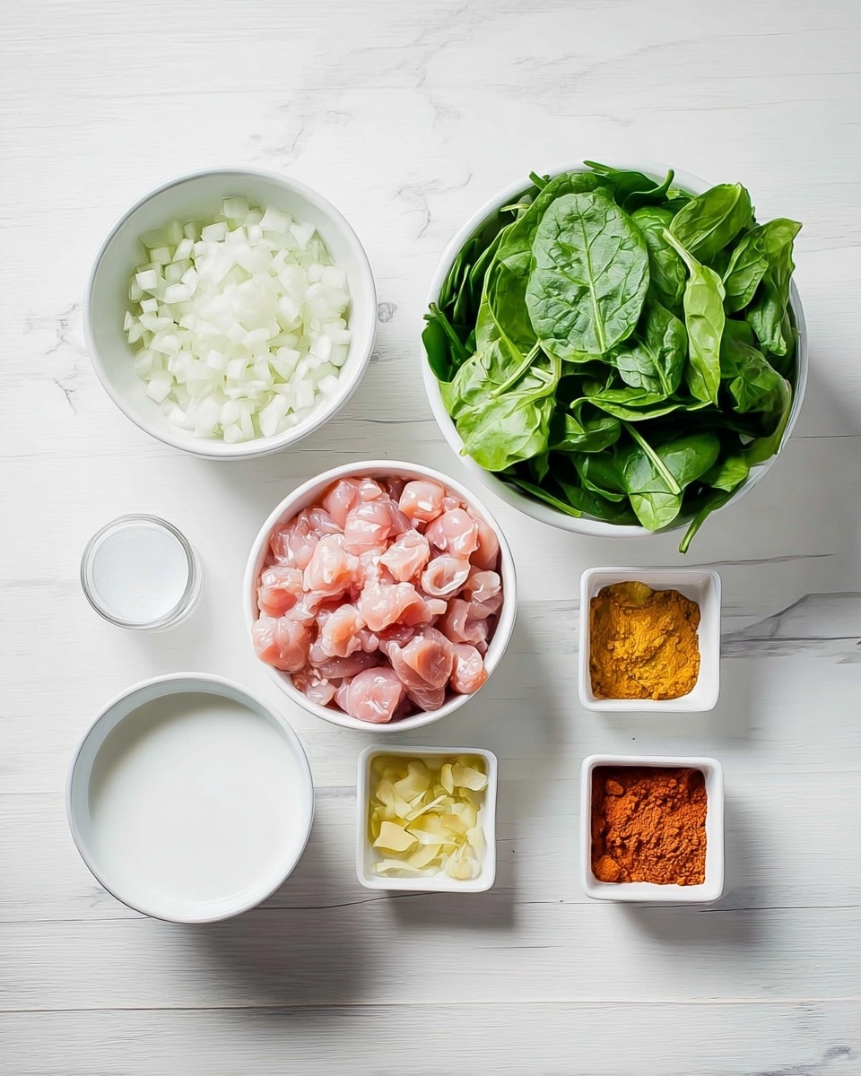 The image shows six white bowls and dishes on a white marbled surface. Starting from the top left, there is a white bowl filled with small white onion pieces, and beside it, a larger white bowl filled with fresh green spinach leaves that look crisp. At the bottom left, there is a smaller white bowl containing a white liquid, likely coconut milk. Next to it, there is a medium-sized white bowl filled with small pink pieces of raw chicken meat. On the bottom right, there are two small square white dishes, one filled with a reddish-orange powder, probably a spice, and the other with finely chopped light yellow ginger. The whole scene is bright and clean, with the bowls neatly arranged and no clutter, showing all ingredients clearly. Photo taken with an iphone --ar 4:5 --v 7