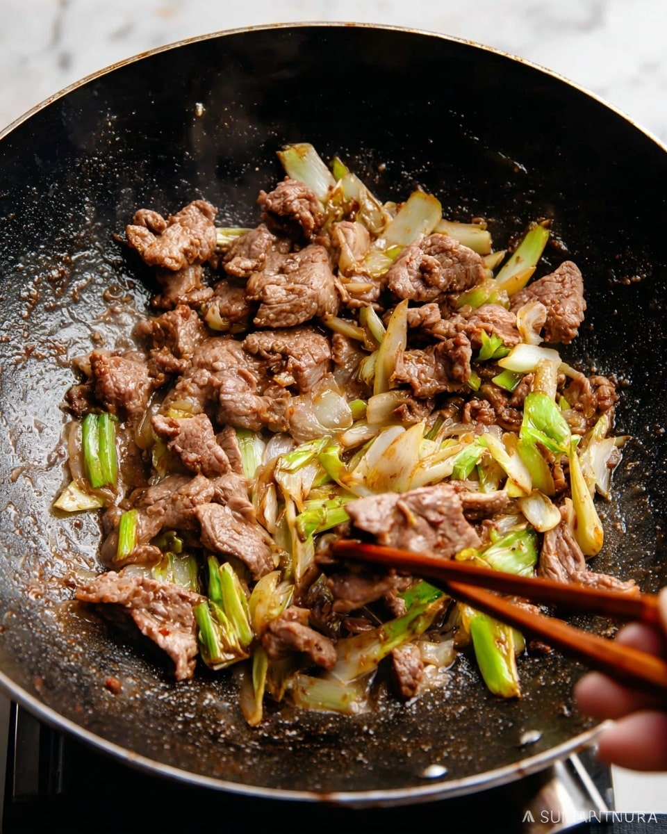 This image shows thin slices of cooked brown meat mixed with light green and white pieces of cooked onion inside a black wok. The meat looks soft and tender, with a slightly shiny texture from the cooking oil bubbling around it. The onions have a soft, slightly browned appearance. A woman's hand is holding two wooden chopsticks that are picking up some of the meat and onion from the wok. The background surface is a white marbled texture. Photo taken with an iphone --ar 4:5 --v 7