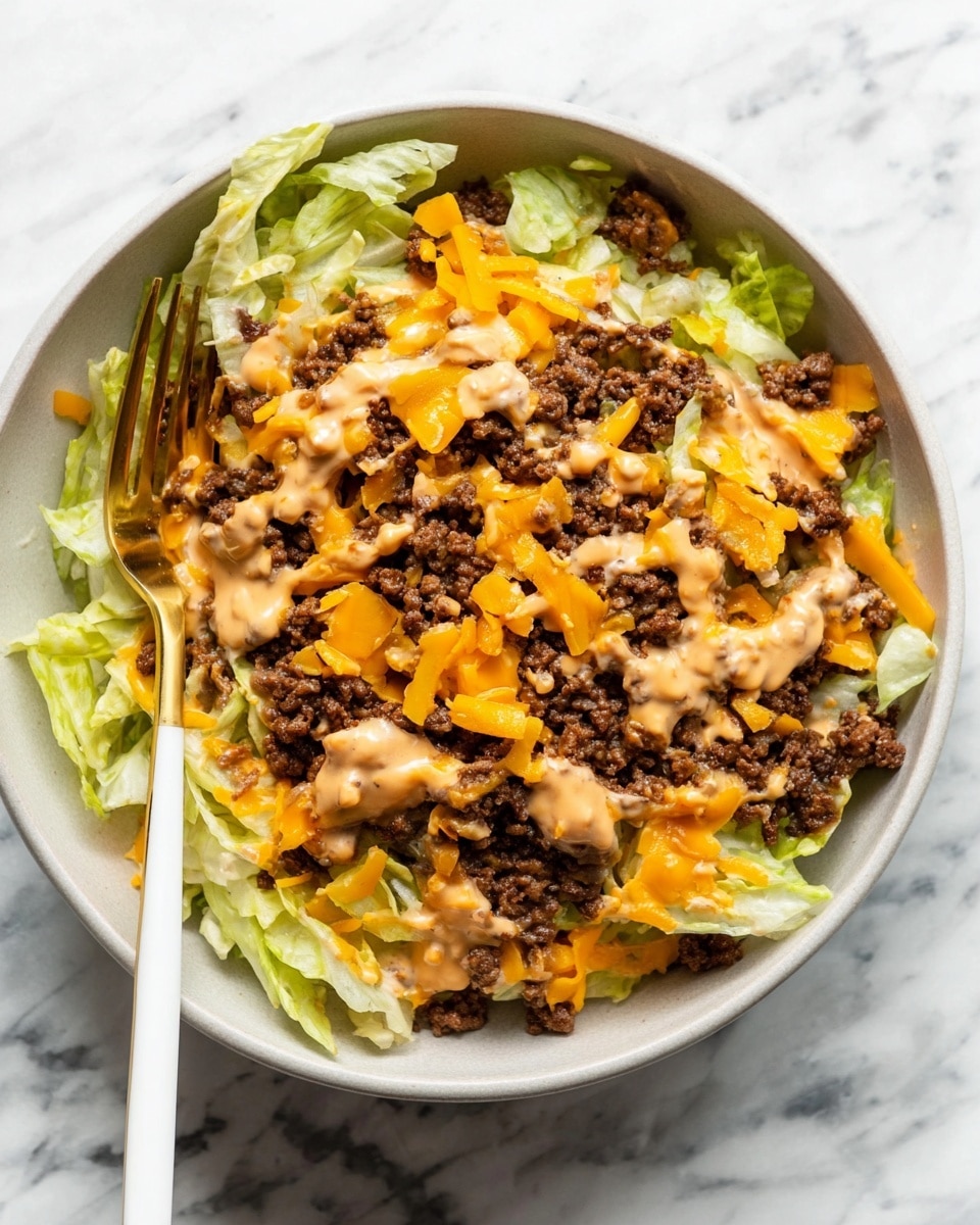 A white bowl holds a layered dish with a base of light green shredded iceberg lettuce, topped with a generous layer of cooked ground beef that is dark brown and crumbly. Scattered over the beef are small pieces of bright orange shredded cheddar cheese. On top there are dollops of a light brown creamy sauce spread unevenly across the beef and cheese. A gold fork with a white handle rests inside the bowl near the left edge, slightly piercing the food. The bowl is on a white marbled surface. photo taken with an iphone --ar 4:5 --v 7