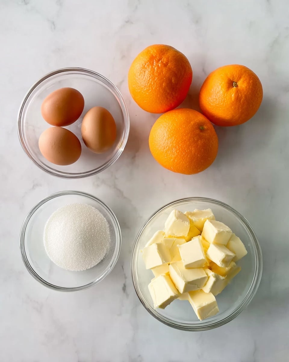 The image shows five ingredients arranged on a white marbled surface: three bright orange oranges positioned on the top right, a clear glass bowl holding three brown eggs on the left side, a smaller clear glass bowl filled with small cubes of pale yellow butter near the bottom right, and a white bowl full of white granulated sugar located at the bottom left. The ingredients are spaced apart with no overlap, creating a simple, clean layout. Photo taken with an iphone --ar 4:5 --v 7