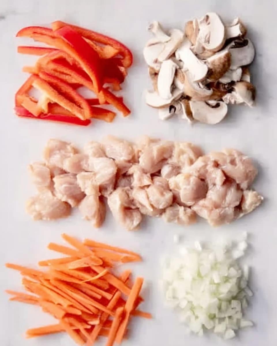 The image shows four groups of raw ingredients laid out on a white marbled surface. At the top left, there are thin strips of red bell pepper with a smooth texture. At the top right, there are small white and brown mushroom slices with soft textures. Below these, in the middle, there is a row of small, light pink pieces of raw chicken arranged neatly. At the bottom left, there are thin orange carrot sticks, and at the bottom right, there is finely chopped white onion with a slightly moist texture. Photo taken with an iphone --ar 4:5 --v 7