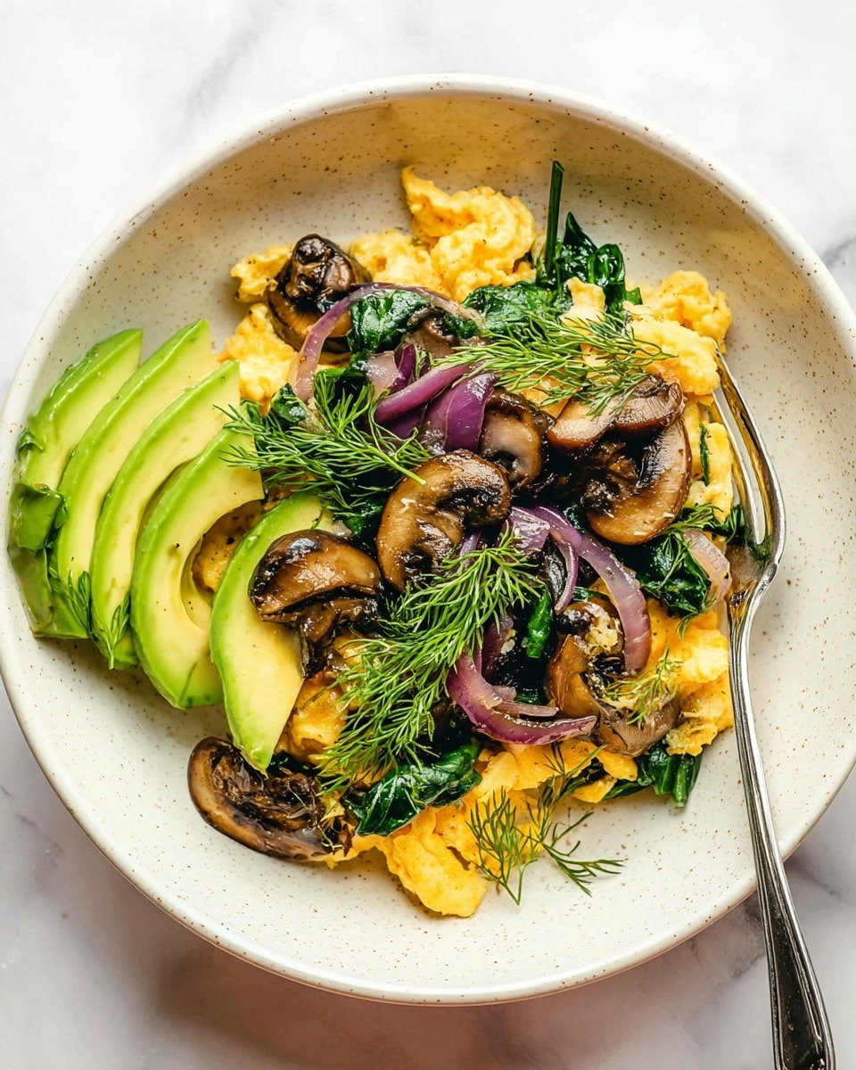 The dish is served in a white bowl with a speckled texture, placed on a white marbled surface. Inside the bowl, the base layer consists of soft, yellow scrambled eggs. On top, there are dark brown sautéed mushroom slices and vibrant green cooked spinach leaves scattered evenly. Thin slices of purple-red onion are mixed in, adding contrast. On the left side of the bowl, there is a fan of light green avocado slices. The dish is garnished with fresh, bright green dill sprigs placed across the top. A shiny silver fork rests inside the bowl, crossing from the top right towards the center. photo taken with an iphone --ar 4:5 --v 7
