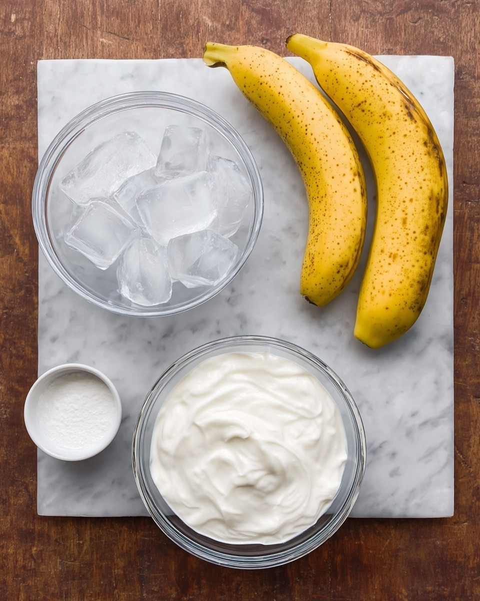 The image shows a top view of four ingredients placed on a white marbled surface. At the top right, two yellow bananas with brown spots lay side by side. Just below the bananas, a small white bowl holds a fine white powder. To the left of it, a clear bowl filled with ice cubes stands prominently, showing the cold translucence of the ice. Above the ice bowl, there is another bowl filled with thick white yogurt or cream, with soft swirls on its surface. The colors are natural and the scene is simple and clean, focused on the ingredients alone. photo taken with an iphone --ar 4:5 --v 7