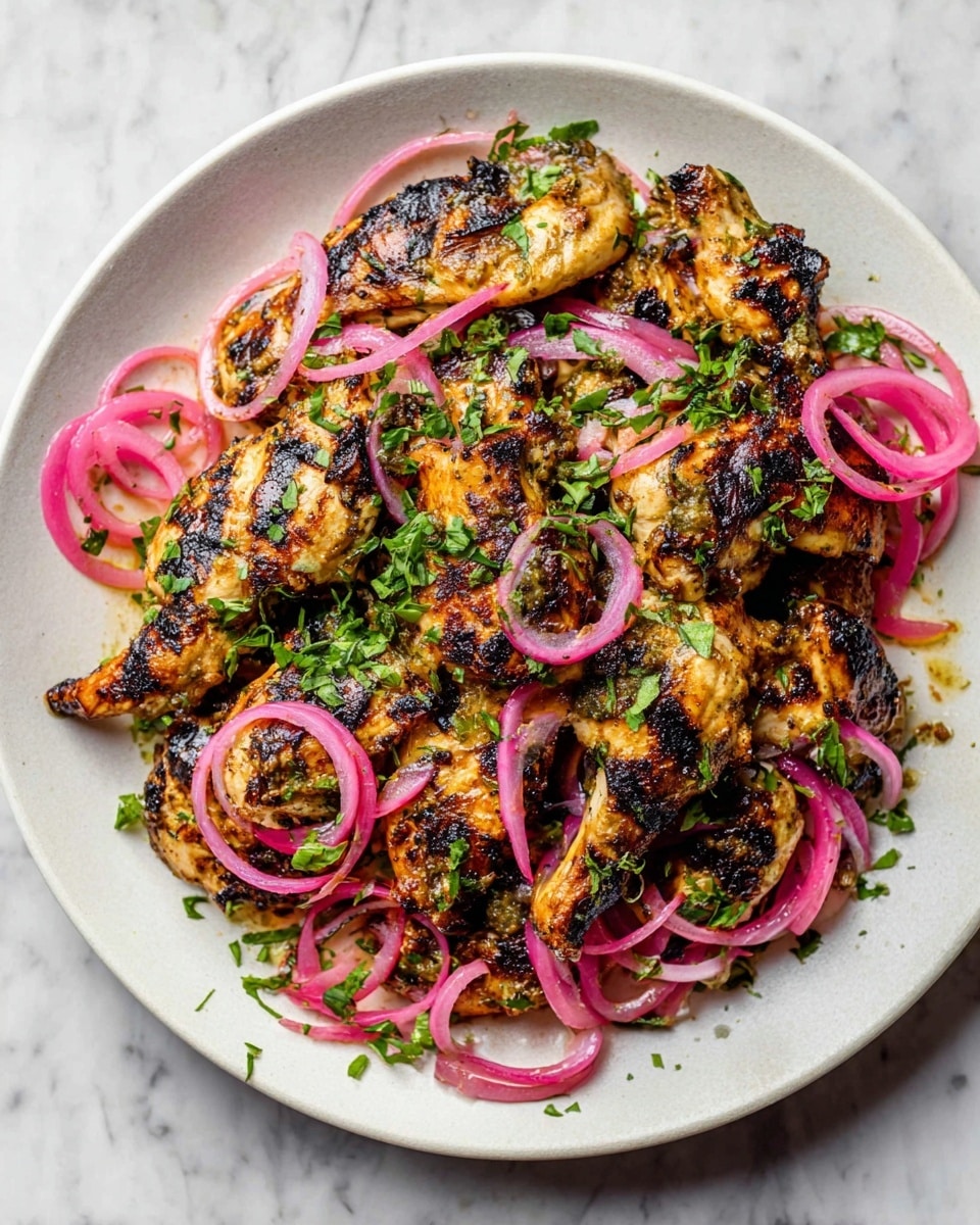 A white plate is filled with a layer of grilled chicken pieces, golden brown with dark grill marks showing a charred texture. On top, there are thin rings of bright pink pickled onions scattered evenly, adding a pop of color. Fresh green chopped herbs are sprinkled across the chicken and onions, giving a fresh contrast. The background is a white marbled surface. photo taken with an iphone --ar 4:5 --v 7