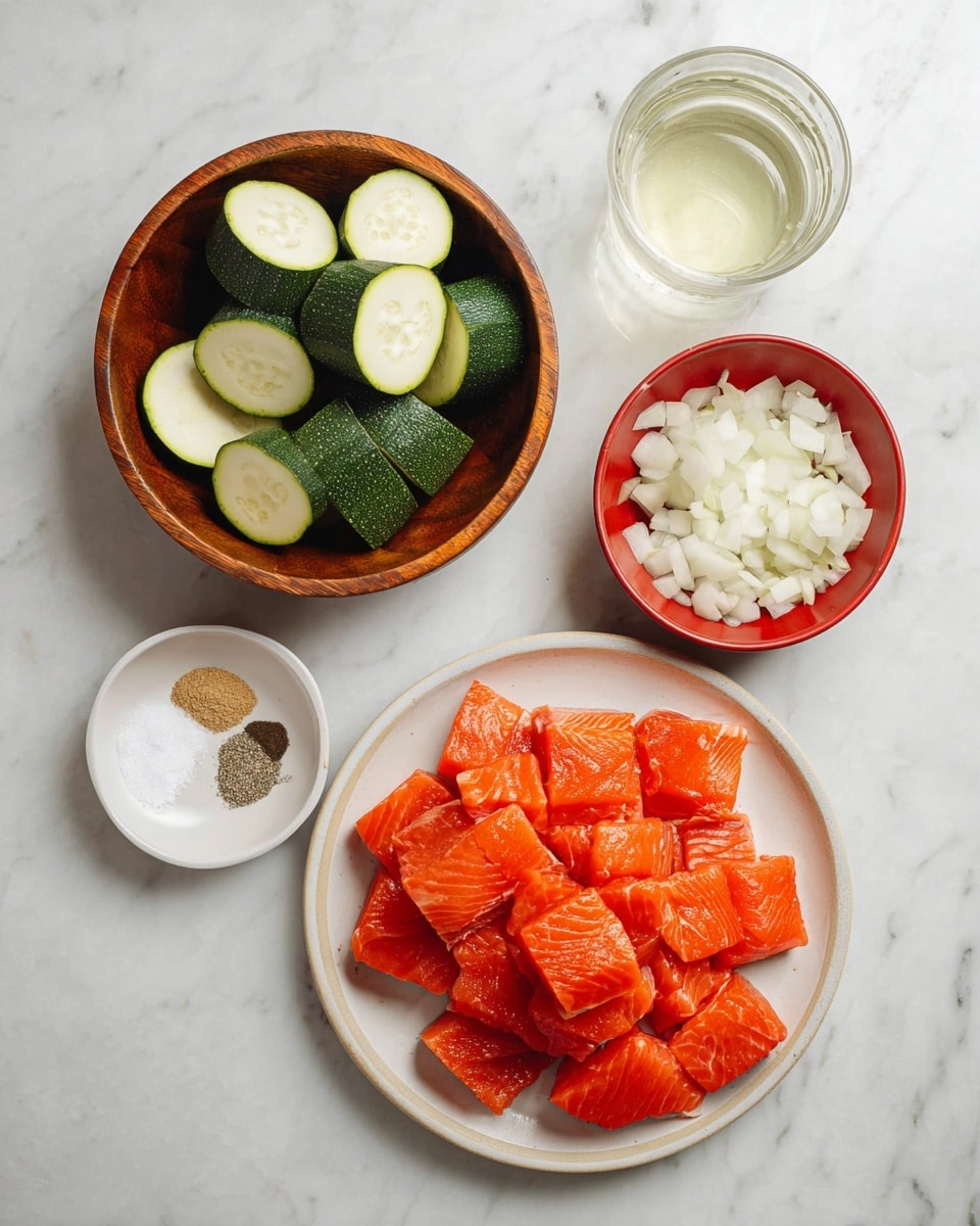 A top view of four white bowls and plates with different ingredients placed on a white marbled surface. The bottom right plate holds about 20 thick, square-shaped pieces of bright orange raw salmon arranged in a loose pile with visible fish texture. The bottom left bowl is wooden and filled with thick, half-moon shaped slices of green zucchini with pale inner flesh, stacked in layers. Above it, a small white bowl contains three seasonings in separate small mounds: white salt, black pepper, and light brown garlic powder. To the right is a small red bowl filled with white onion pieces, roughly chopped into medium chunks. At the top right corner, there is a clear glass filled with white liquid, possibly oil or vinegar. photo taken with an iphone --ar 4:5 --v 7
