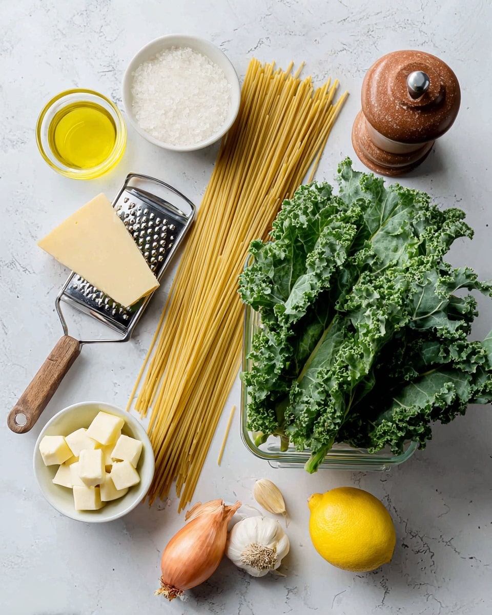 The image shows ingredients for a pasta dish laid out on a white marbled surface. There is a large clear container filled with fresh green kale leaves positioned on the right side. A long bundle of uncooked spaghetti pasta lies next to the kale, stretching horizontally across the middle of the image. On the left side, there is a wedge of pale yellow cheese resting on a silver grater with a wooden handle. Surrounding these main items are small bowls and whole ingredients: a small glass bowl of golden olive oil at the top left, a small white bowl with white butter cubes below the kale, a whole bright yellow lemon on the right, a whole shallot with brownish purple skin near the bottom, two cloves of white garlic next to the shallot, a rusty brown pepper grinder near the lemon, and a small terracotta bowl with white salt above the kale photo taken with an iphone --ar 4:5 --v 7