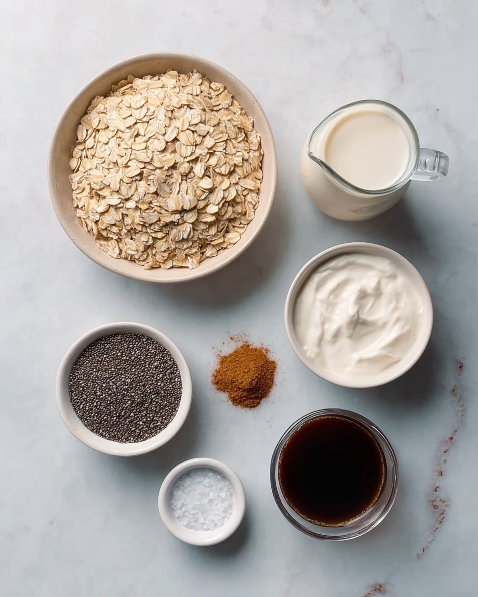 The image shows six small white bowls and glass containers placed on a white marbled surface. The largest bowl is filled with light brown rolled oats and placed at the top left. Next to it on the right is a small clear glass jug with white milk. Below them, from left to right, there is a white bowl with tiny black chia seeds, a small white bowl filled with smooth white yogurt, and another white bowl containing brown ground cinnamon. At the bottom center, there is a tiny white bowl with a pinch of coarse salt. In the middle between the bowls, there is a glass container filled with dark brown liquid, likely coffee. The setup is neat and minimalistic, with each ingredient clearly visible and separated. Photo taken with an iphone --ar 4:5 --v 7