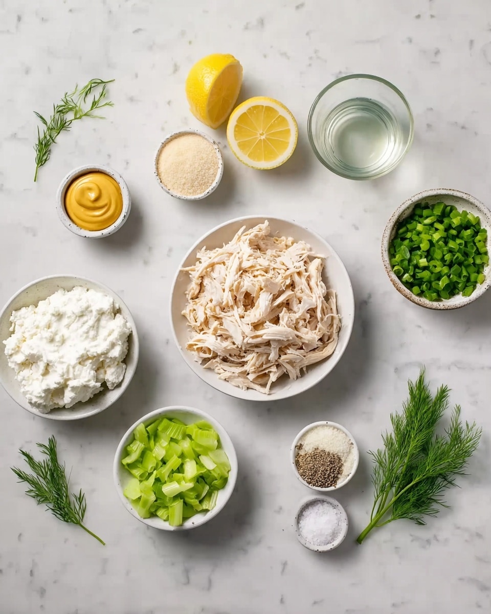 The image shows several small white bowls arranged on a white marbled surface, each holding different ingredients. In the center is a bowl full of shredded light brown chicken, surrounded by a bowl of thick white cottage cheese above it, a bowl of chopped green celery below, a small bowl of yellow mustard to the left, half a lemon cut with bright yellow flesh in the top left corner, a tiny bowl of light beige powder below the celery, a small glass container of clear liquid above the chicken, a small bowl of chopped green onions to the top right, and a small bowl with salt and pepper below the onions. A small sprig of fresh green dill is placed on the marble surface near the salt and pepper. The setup is neat and clean, showing all ingredients for a recipe clearly, photo taken with an iphone --ar 4:5 --v 7